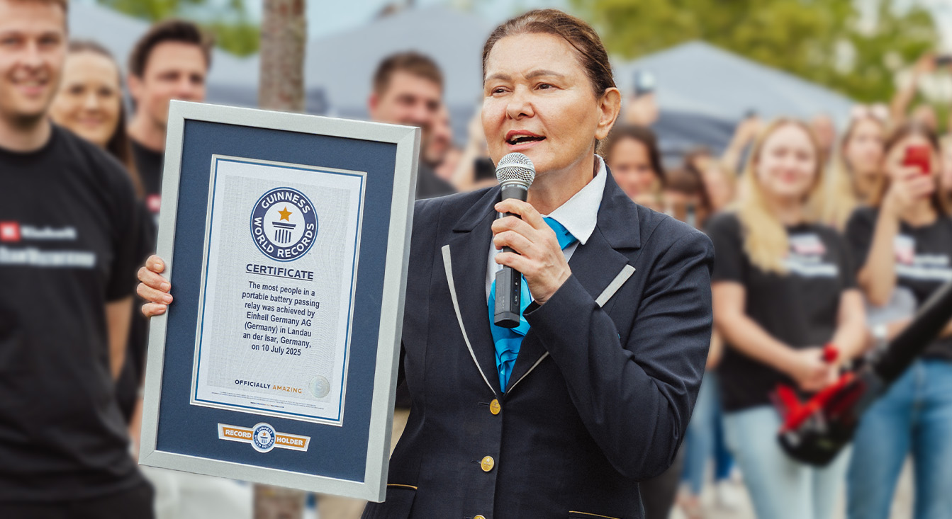 Resmi Guinness üniformasıyla olan bir kadın Einhell'in akü dünya rekorunu geçişinin sertifikasını tutuyor.